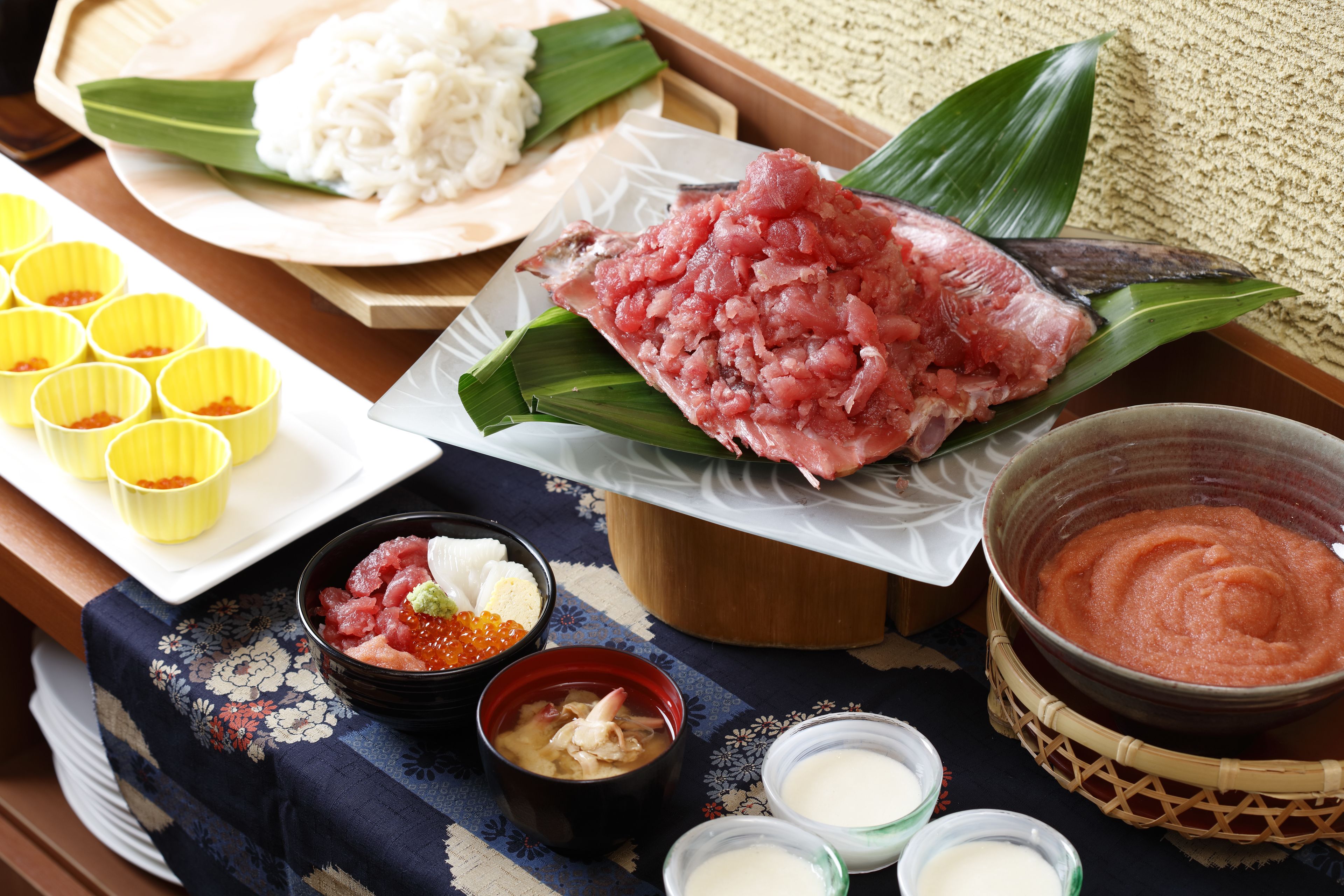 Una comida tradicional japonesa con diversos platos, incluyendo sashimi, arroz y sopa.