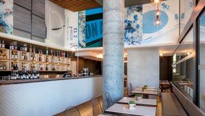 A modern bar area with a variety of liquor bottles, a counter, and seating arrangements.