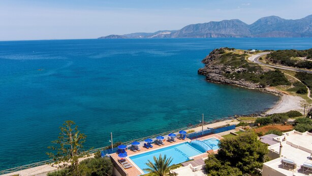 Ett semesterhotell med pool, tillgång till stranden och utsikt över bergen.