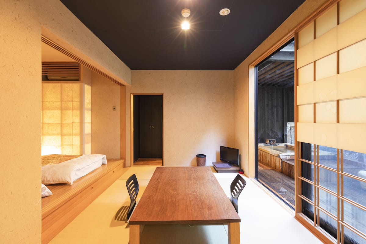 A traditional Japanese-style room with tatami flooring, a low wooden table, and sliding doors.