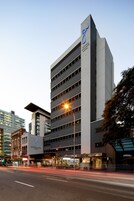 A George Williams Hotel building with a modern design, multiple floors, and a prominent 'George Williams Hotel' sign.