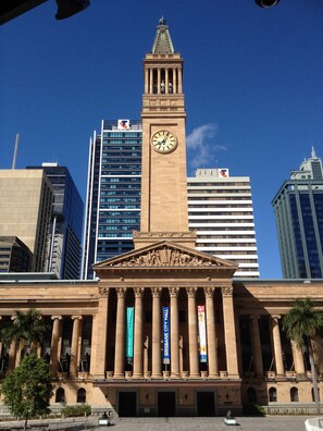 A classical building with a clock tower, columns, and banners. - George Hotel Brisbane, Independent Collection by EVT (Brisbane)