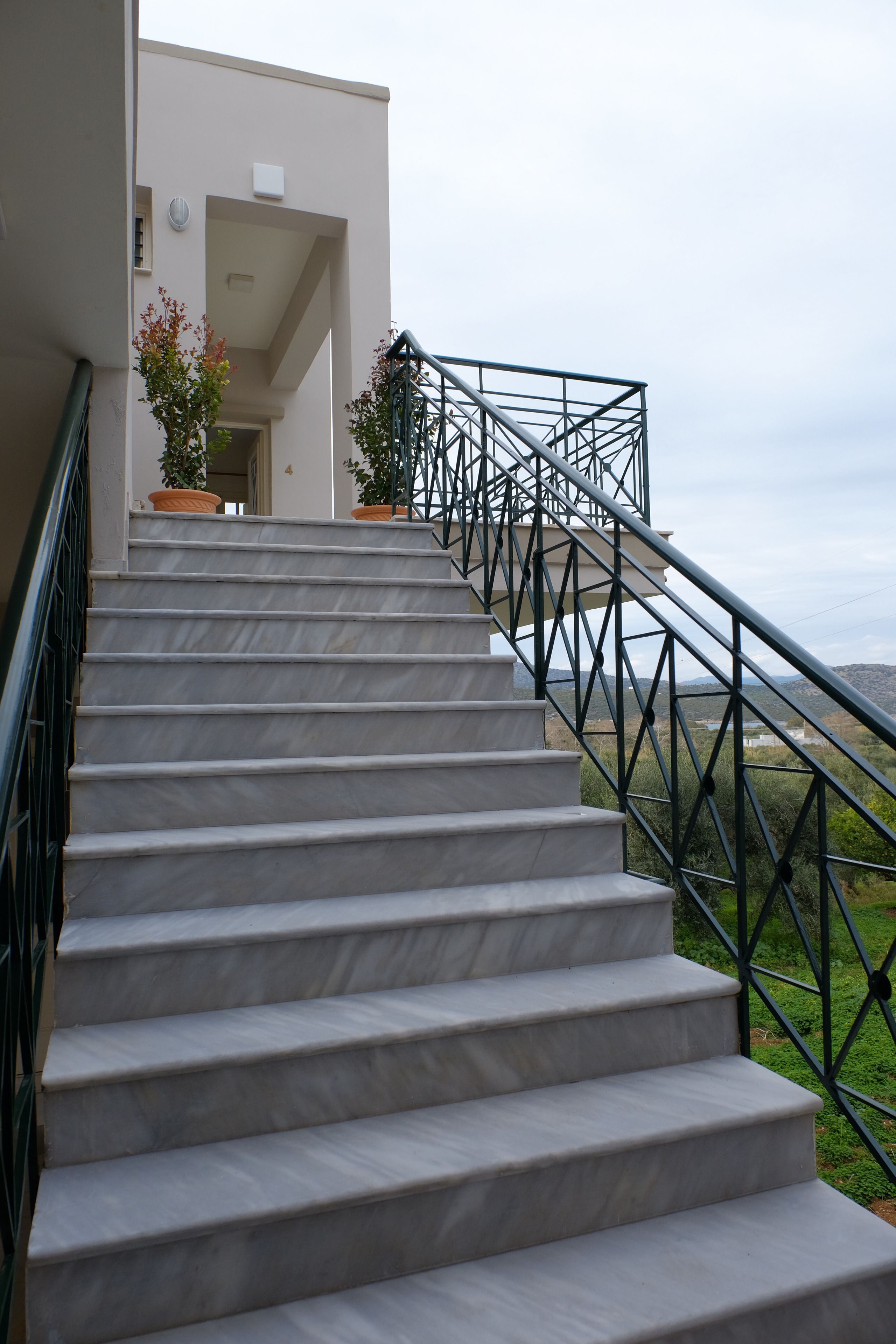 A staircase with a metal railing leading to a building entrance.