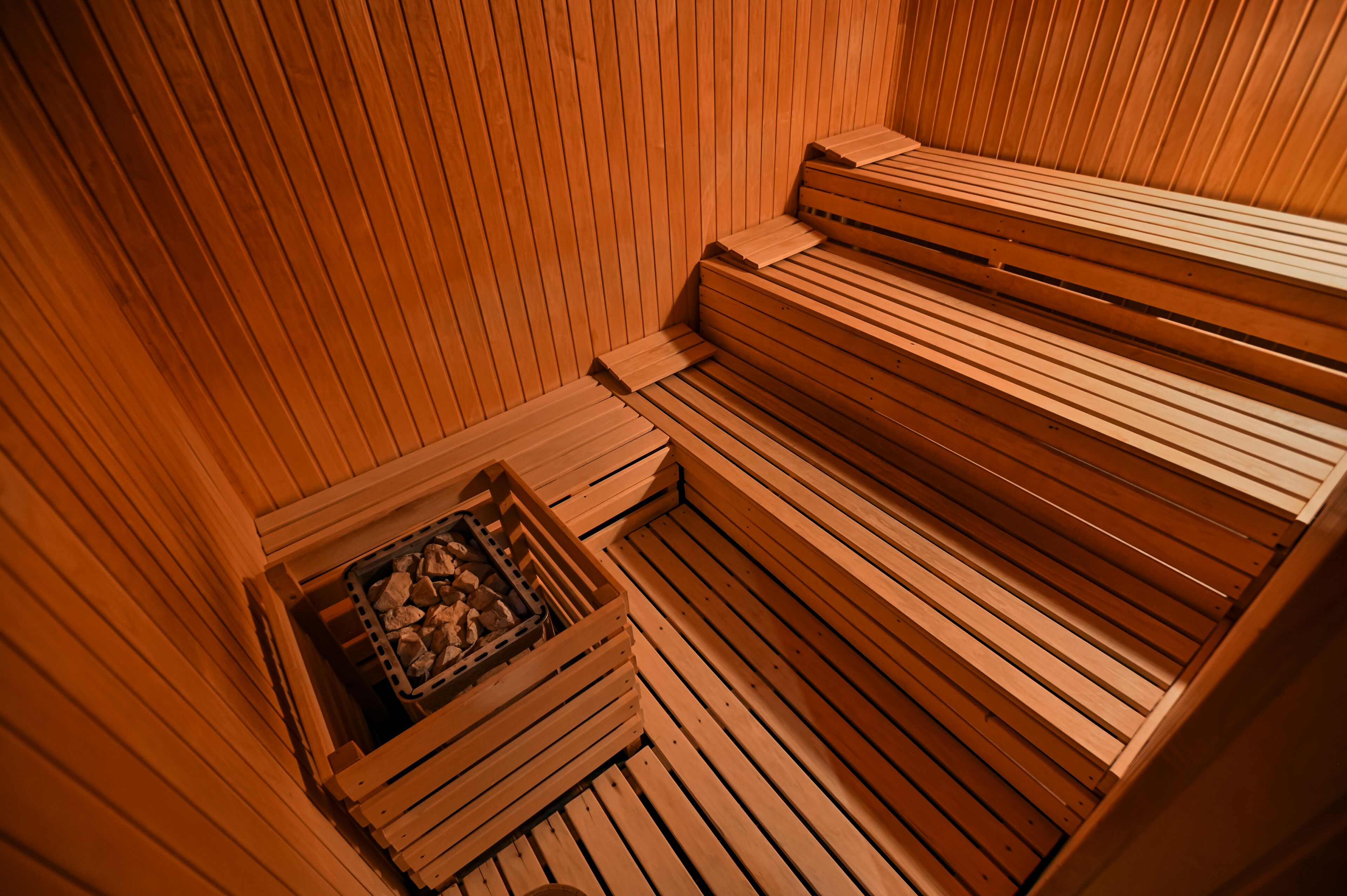 Una sauna con bancos de madera y un calentador de piedra.