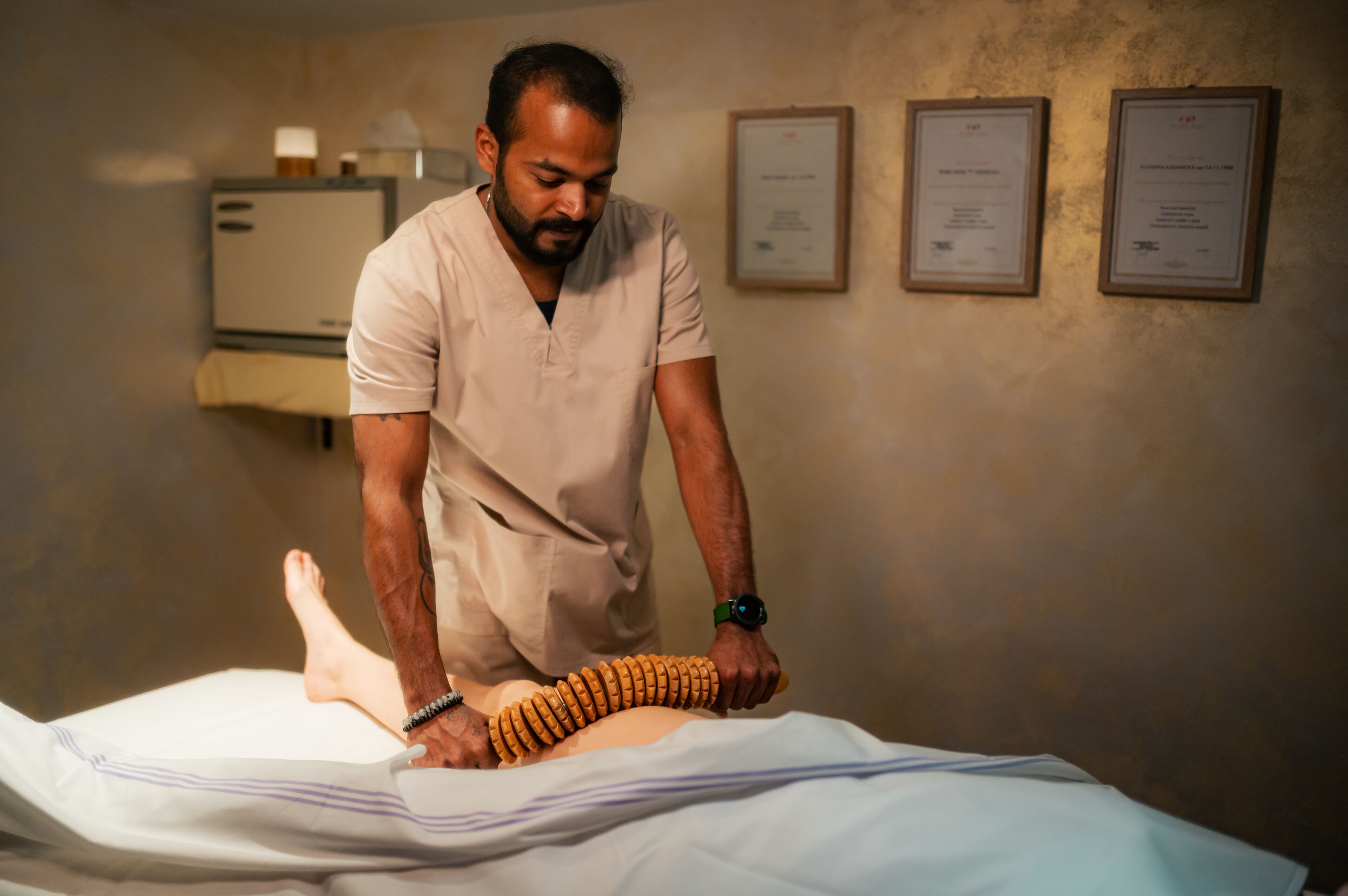 A person performing a physical therapy session on a patient lying on a treatment table.