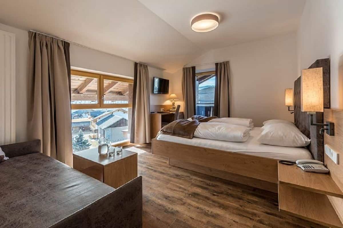 Ein Hotelzimmer mit Bett, Nachttisch, Lampe und Fernseher.