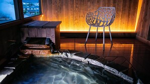 A wooden interior with a wooden wall, a chair, and a hot spring area. - Kunisakiso (Beppu)