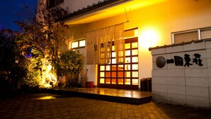 A traditional Japanese building with a tiled entrance and a sign with Japanese characters. - Kunisakiso (Beppu)