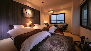 A hotel room with two beds, a large window with a view, a desk, and a chair. - Kunisakiso (Beppu)