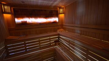 A sauna with wooden benches and a visible heat source.