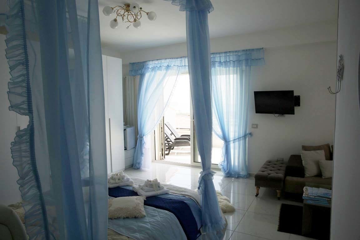 Une chambre à coucher avec un lit, une télévision et un canapé.