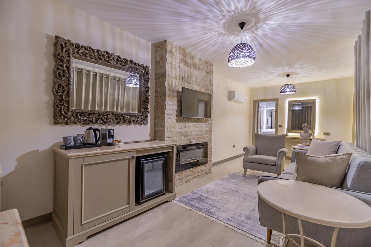 Una sala de estar moderna con chimenea, televisor montado en la pared, sofá y una mesa de centro.