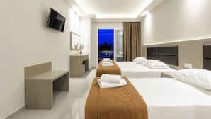 Habitación de hotel moderna con dos camas, un banco, un televisor y vistas del cielo al atardecer.