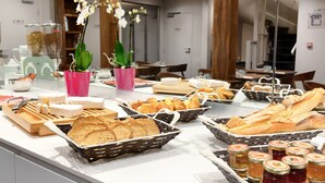 Een buffet met diverse broden, gebak en confituur.