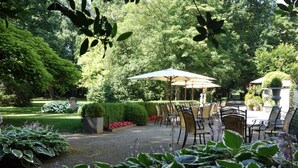 A garden patio with outdoor seating, surrounded by lush greenery and a variety of plants. - Kasteel van Nieuwland (Aarschot)