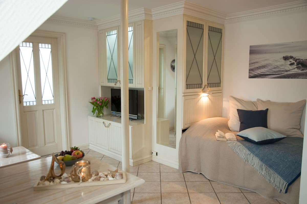 Une chambre confortable avec un lit, une table de chevet et un téléviseur.