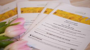 Une brochure contenant du texte et une tulipe rose.