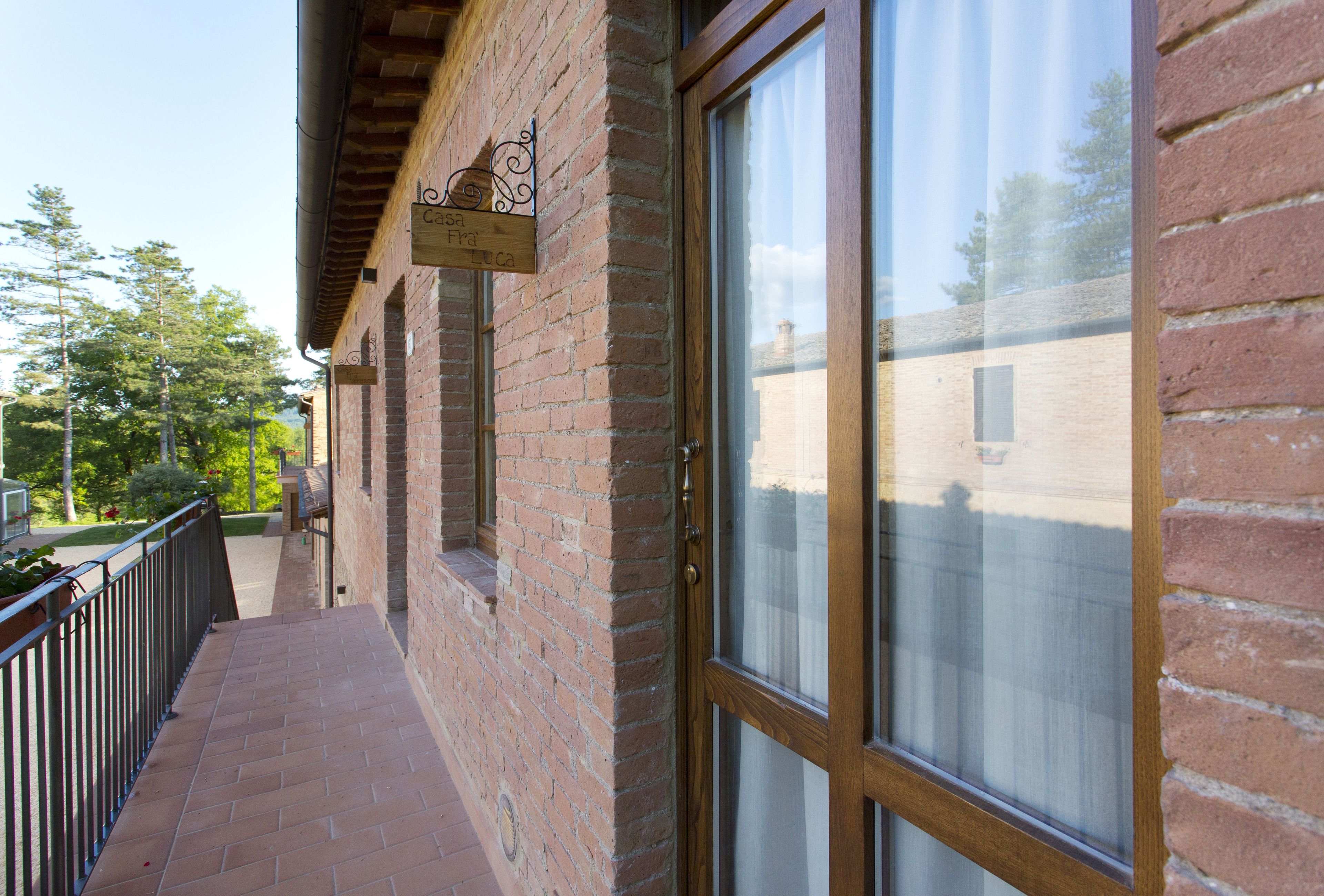A brick building with a wooden balcony and a large window.