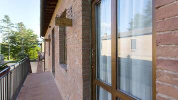 A brick building with a wooden balcony and a large window.