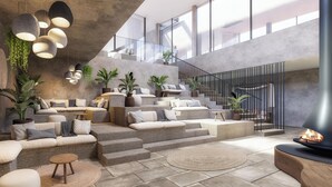 Un espace de vie moderne avec une cheminée en pierre, des meubles en osier et de grandes fenêtres.
