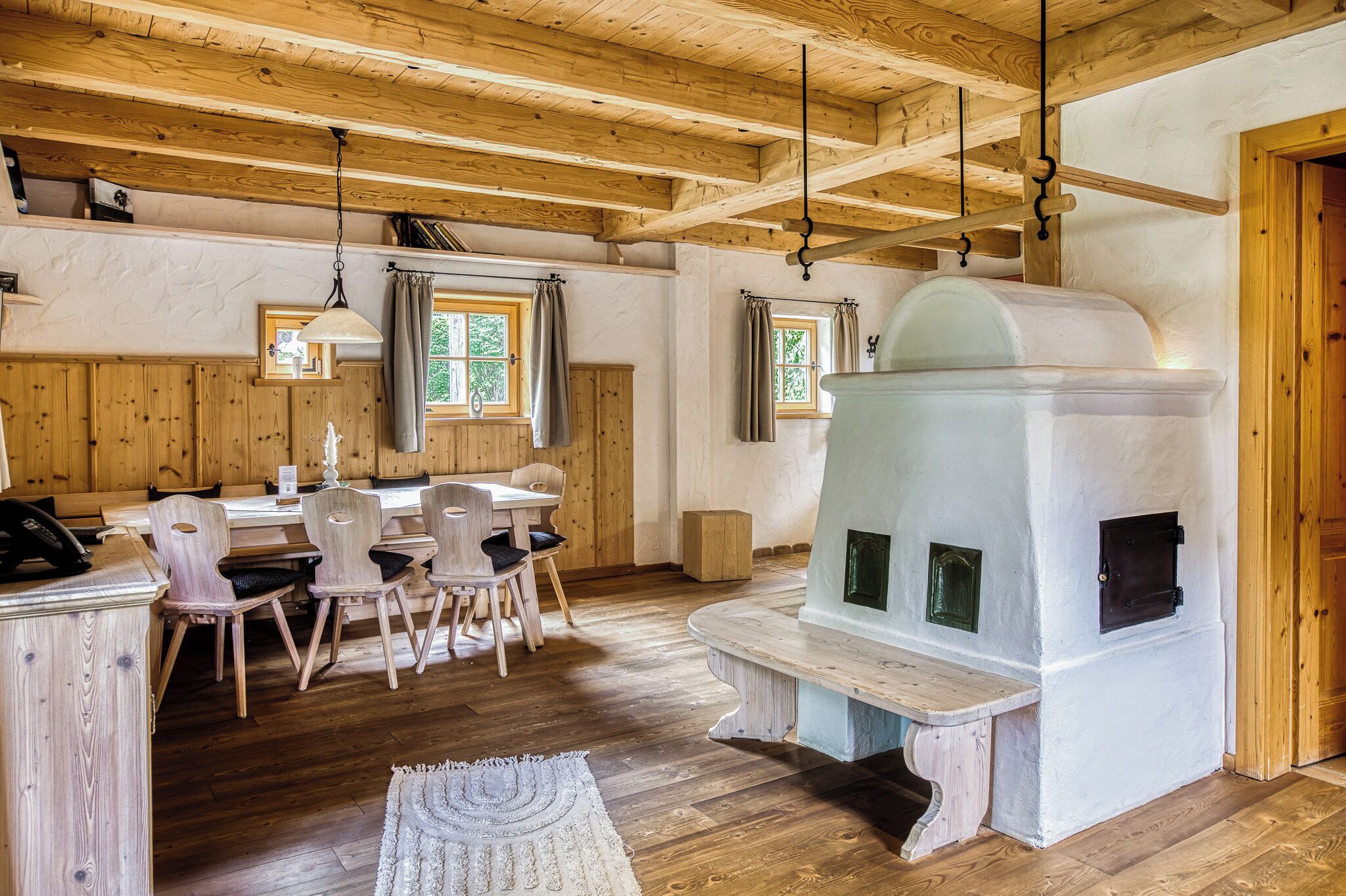 A wooden interior with a dining area, a fireplace, and a wooden ceiling.