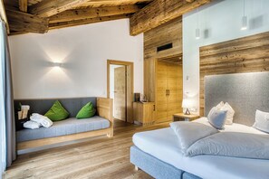 Et moderne hotelværelse med træloft, en sofa med grønne puder, en seng med hvide sengetøj og en træskab.