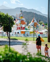 Un parque acuático con coloridas estructuras de juego y un paisaje montañoso.