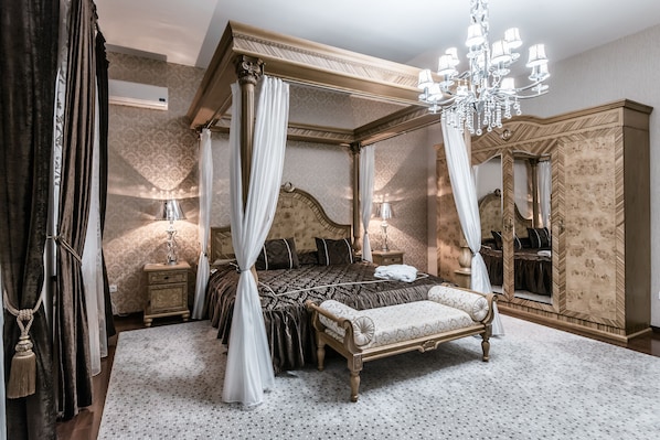 A four-poster canopy bed with a mirror cabinet, a bench, and a nightstand with a lamp. - Ichan Qala Premium Class Hotel (Tashkent)