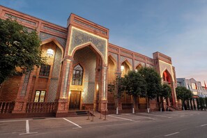 A large brick building with arched windows and intricate tile work. - Ichan Qala Premium Class Hotel (Tashkent)