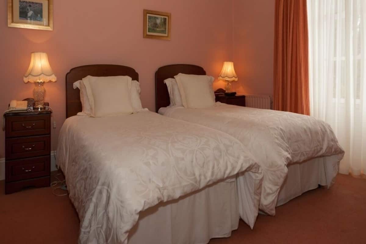 A double bed room with two nightstands, each with a lamp, and a dresser.