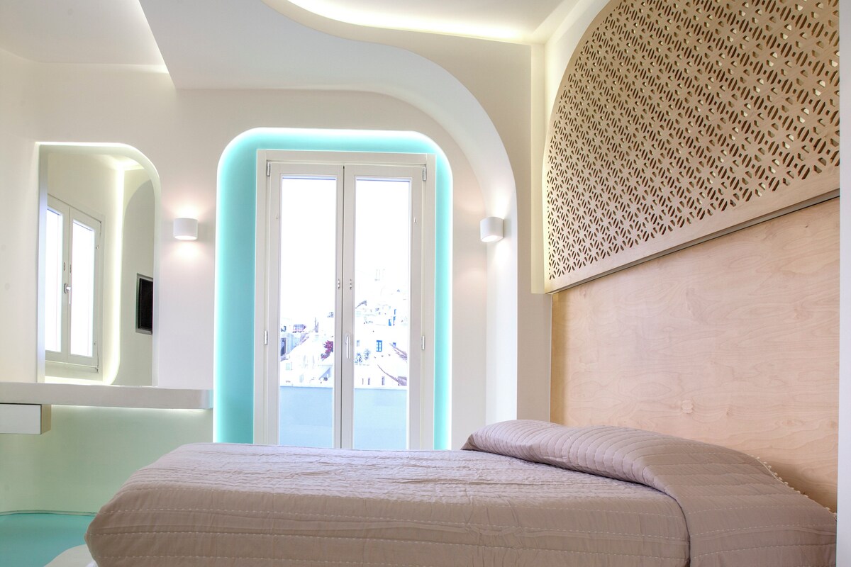 Un dormitorio moderno con cama, vista a edificios a través de un ventanal y un panel de madera decorativo en la pared.