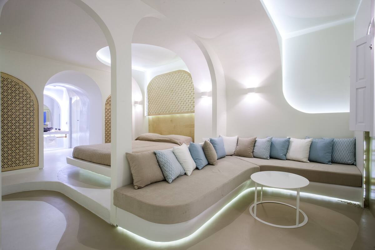A modern interior with a curved sofa, a round table, and a patterned wall.