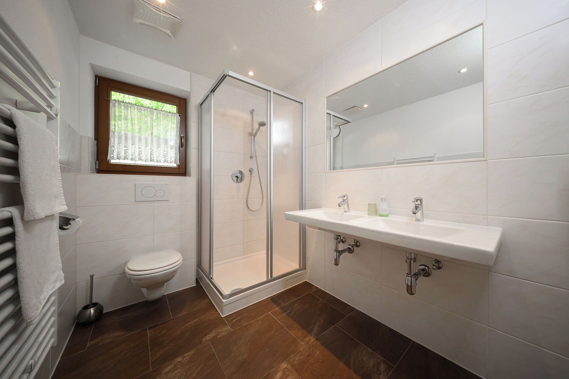 Een badkamer met douche, toilet en wastafel.