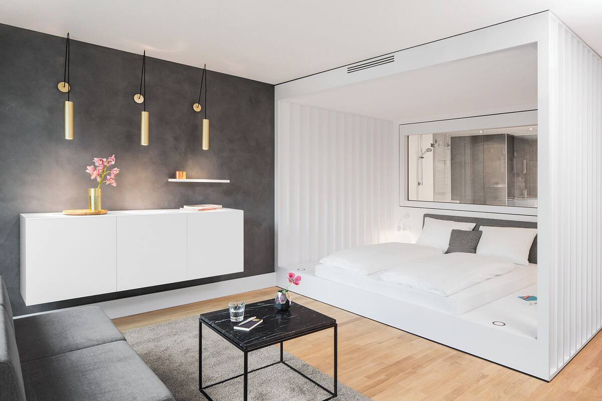 Un dormitorio moderno con cama, mesita de noche y armario empotrado.