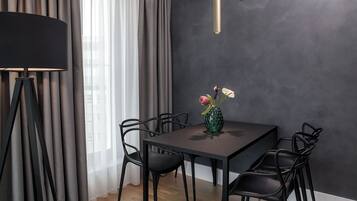 Een moderne eetruimte met een donkere wand, een tafel en stoelen.