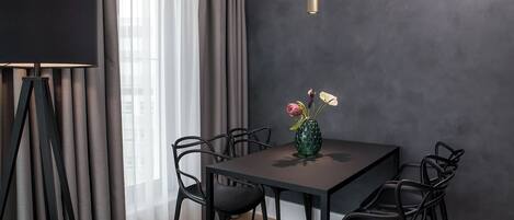 Un comedor moderno con pared oscura, una mesa y sillas.