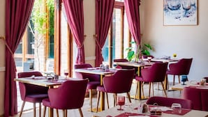 A restaurant with large windows, red curtains, and a painting on the wall. - Domus Ciliota (Venice)