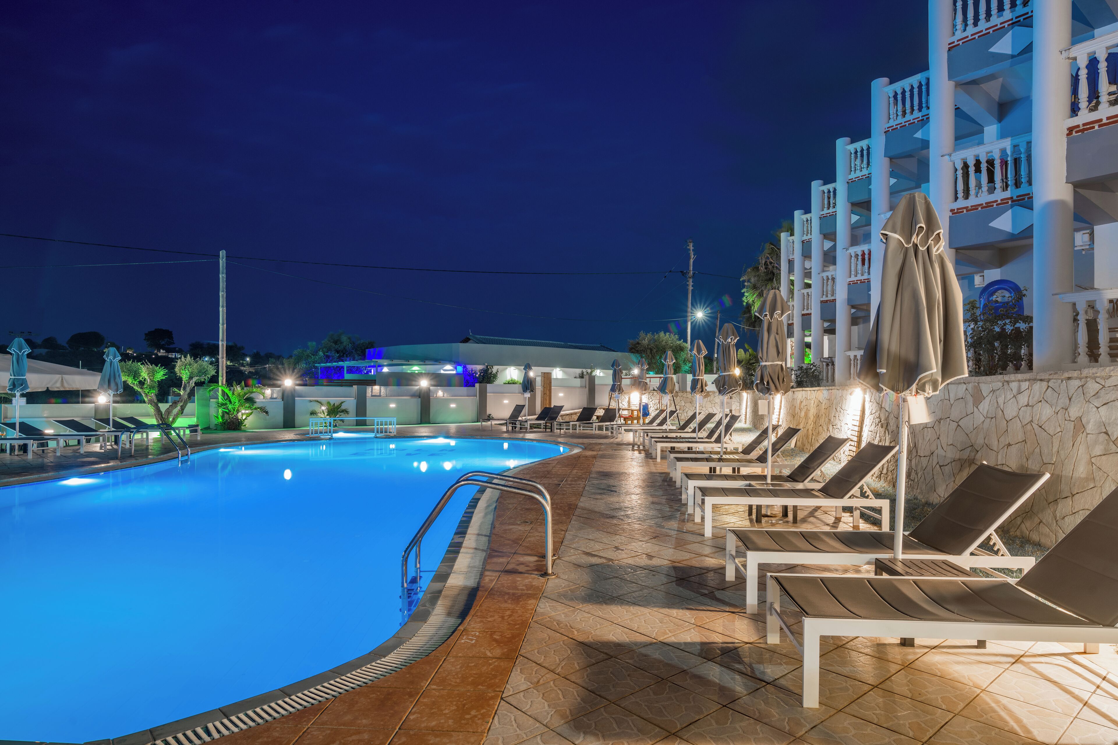 حمّام سباحة خارجي، مظلات على حمّام السباحة، مقاعد للتشمس