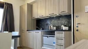 A modern kitchen with wooden cabinets, a black marble countertop, and stainless steel appliances. - Residence Adele (Livigno)