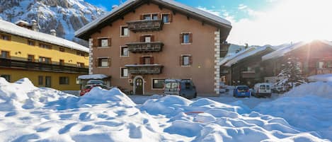 A building with multiple balconies and a snow-covered mountain in the background.
