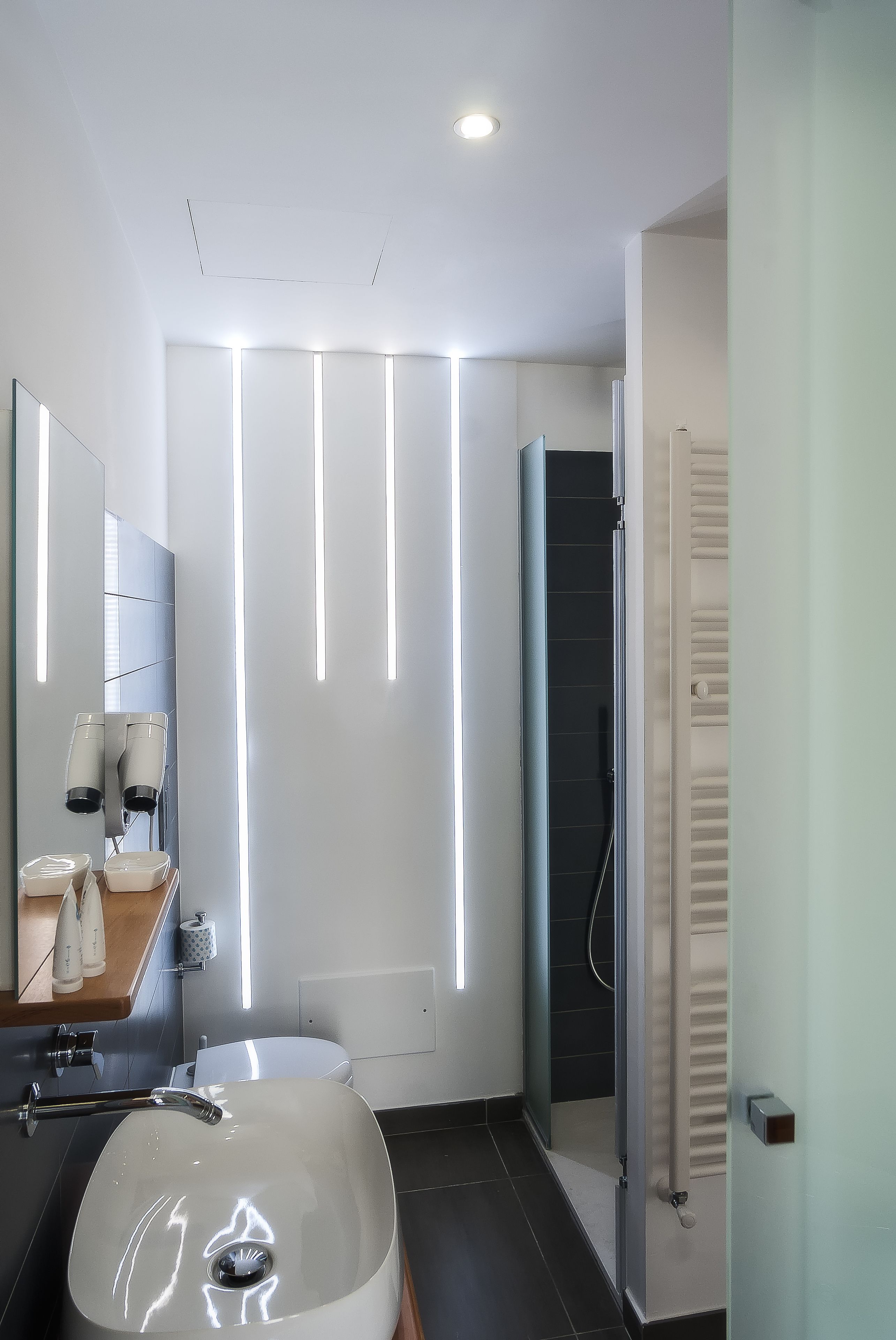 A modern bathroom with a large sink, a mirror, and a shower.