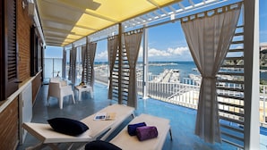 A balcony with sun loungers, a table, and a view of the marina. - La Sciabica (Agropoli)