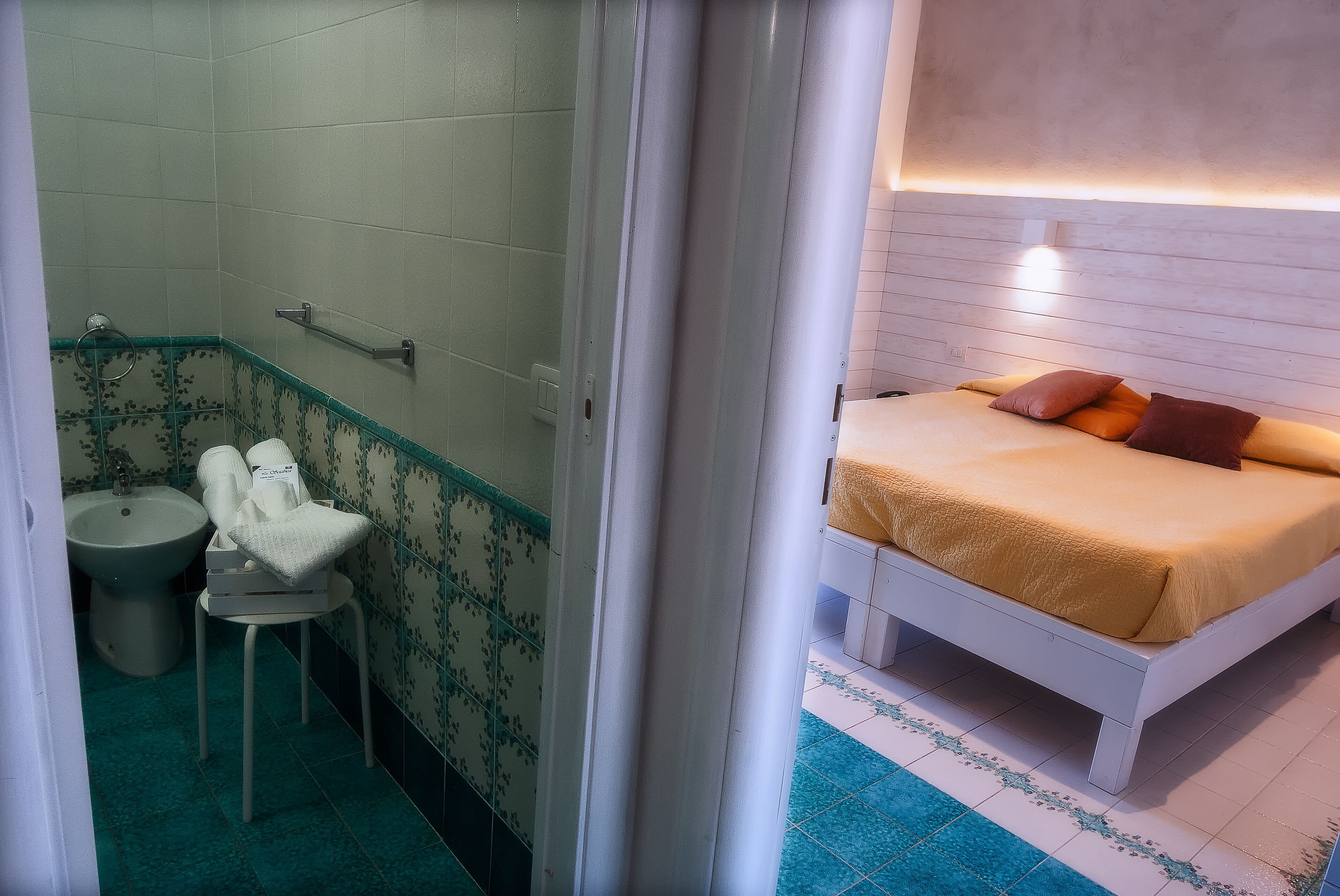 Un baño con bidé, inodoro y un pequeño taburete.