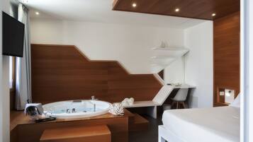 Quarto de hotel moderno com parede de destaque em madeira, uma banheira grande, uma escrivaninha e uma cama.