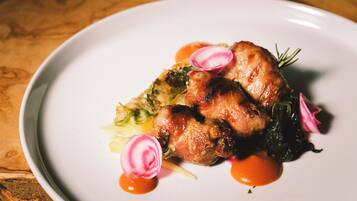 Une assiette de nourriture comprenant un morceau de viande, des légumes et une sauce.