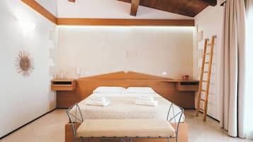 A bedroom with a wooden headboard, a bench at the foot of the bed, a ladder, and a wall-mounted shelf with a lamp and decorative items.
