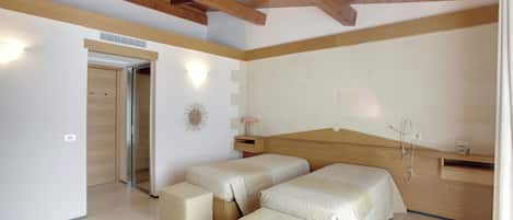 A bedroom with a wooden ceiling, a bed with a wooden headboard, two bedside tables, a nightstand, and a wall-mounted light fixture.