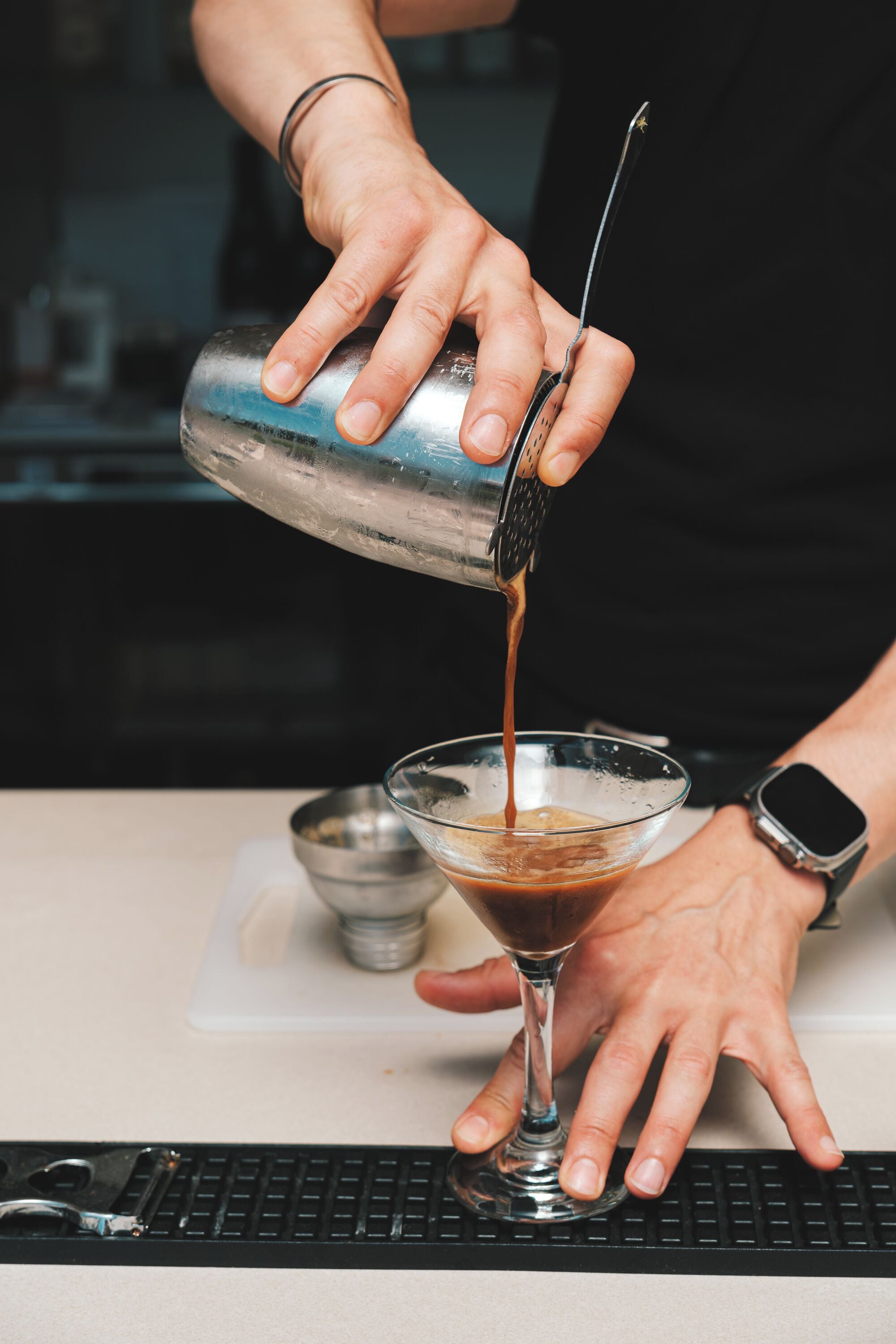 A person pouring a drink into a glass.