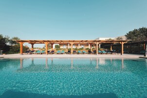 Una piscina al aire libre de temporada, sombrillas
