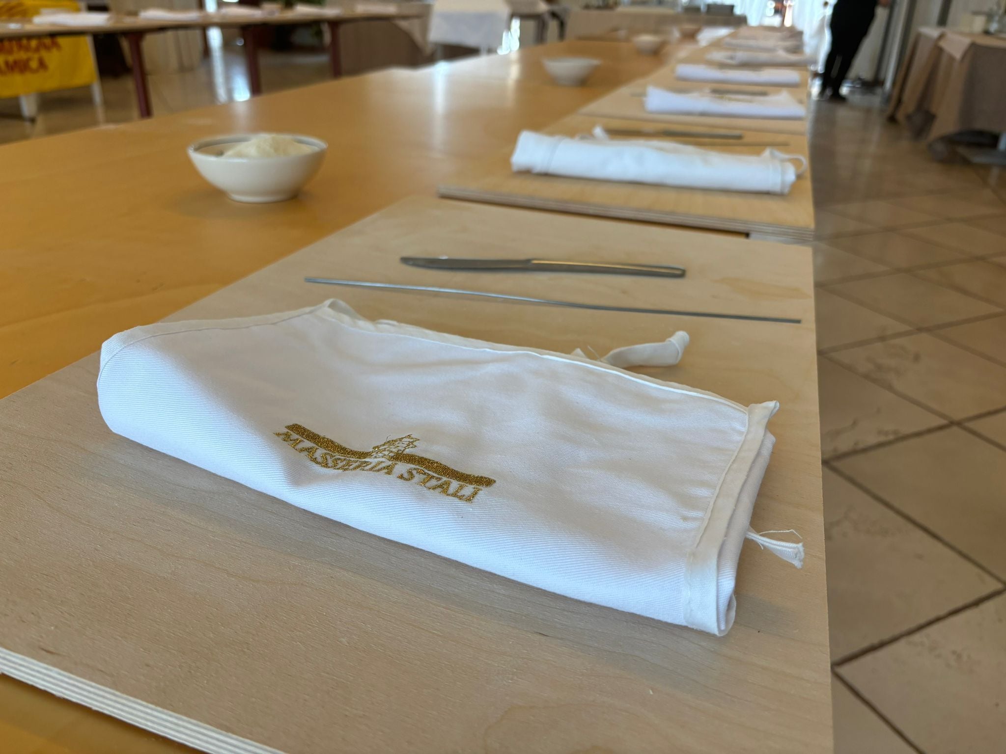 Een netjes gedekte tafel met gevouwen witte servetten en een schaal rijst.